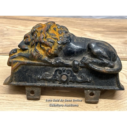 312 - A pair of cast iron lion finials / 22cm l x 15cm h