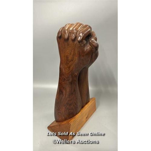 95 - Large carved wooden sculpture of praying hands on a seperate wooden base, 46cm high, base 24.5cm wid... 