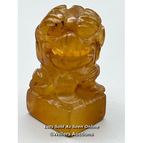 128 - A pair of small carved orange jade foo dogs, each 4.5cm high / AN47