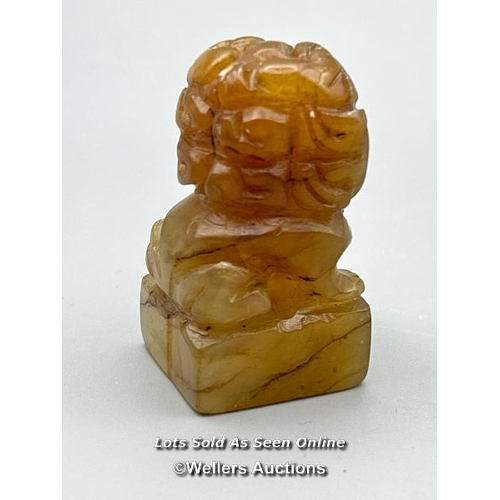 128 - A pair of small carved orange jade foo dogs, each 4.5cm high / AN47