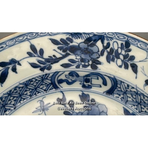 129 - A pair of Kangxi period blue and white shallow bowls decorated with flowers, both 23.5 cm diameter, ... 