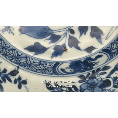 129 - A pair of Kangxi period blue and white shallow bowls decorated with flowers, both 23.5 cm diameter, ... 