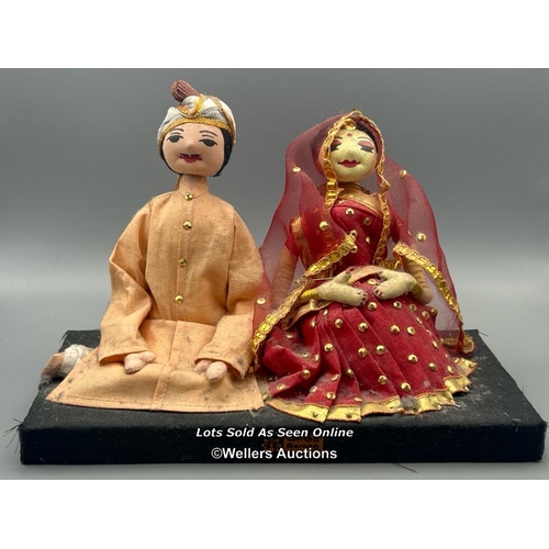 151 - A pair Bangladeshi wedding dolls, 17cm high, a small wooden doll on green stand, 14cm high and a box... 