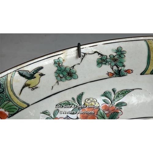 172 - A Chinese famille verte porcelain charger decorated with two long tailed birds, one in flight and th... 