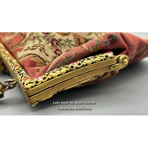 184 - A vintage embroidered evening purse with ornate yellow metal clasp and handle decorated with red and... 