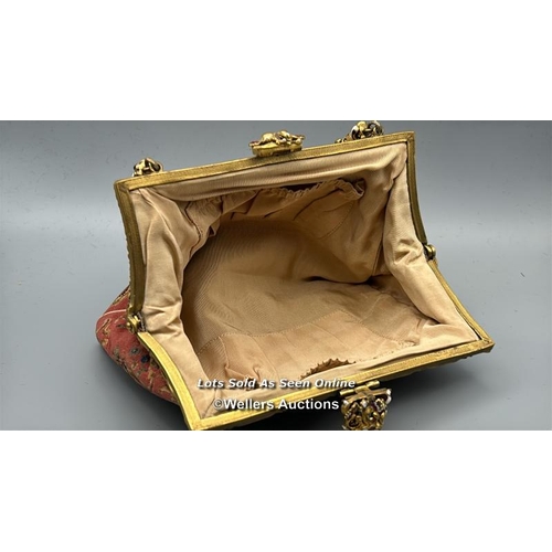 184 - A vintage embroidered evening purse with ornate yellow metal clasp and handle decorated with red and... 