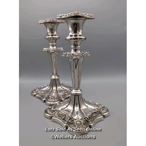 209 - A pair of silver plated candlesticks of a panelled V-stem design on square bases with ornate foliate... 