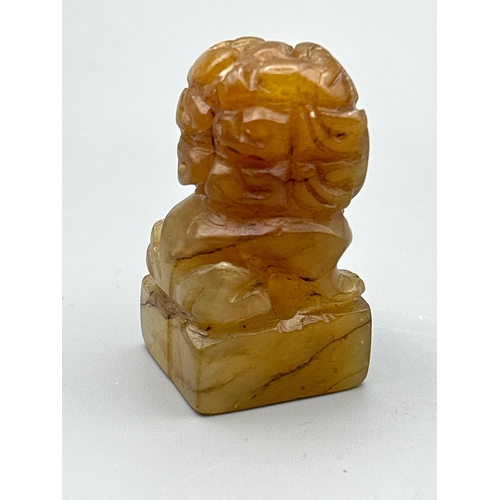 53 - A pair of small carved orange jade foo dogs, each 4.5cm high / AN17