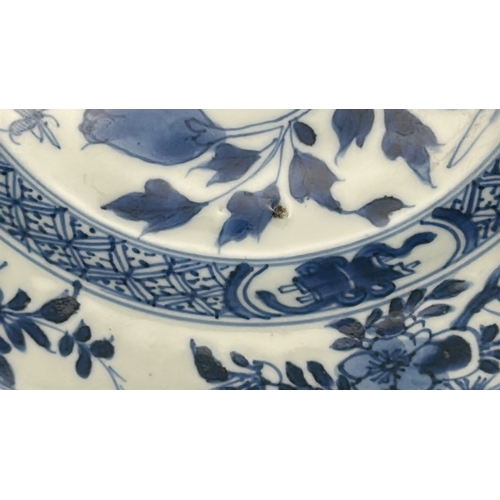 54 - A pair of Kangxi period blue and white shallow bowls decorated with flowers, both 23.5 cm diameter, ... 