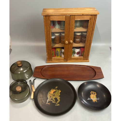 37 - Small spice cupboard with assorted spice pots, wooden serving tray and decorative plates / T15