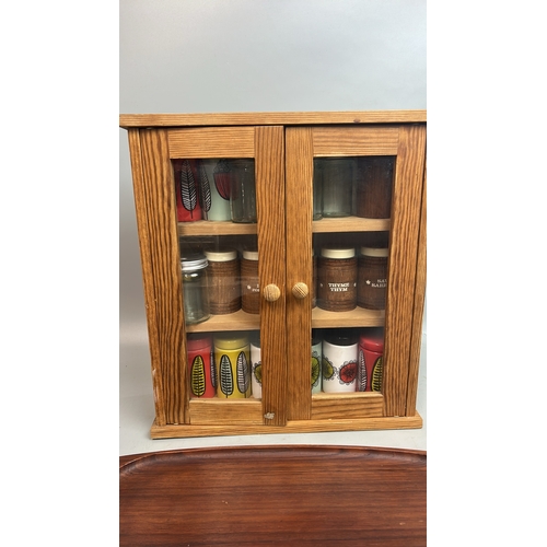 37 - Small spice cupboard with assorted spice pots, wooden serving tray and decorative plates / T15