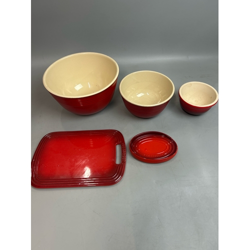 51 - Le Creuset ceramics including three mixing bowls, largest 27cm diameter, cheese board and one other ... 