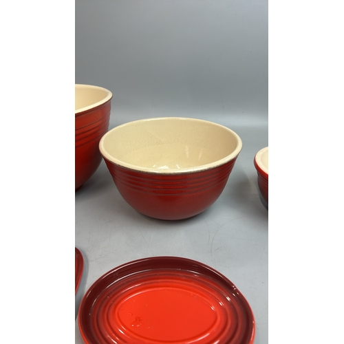 51 - Le Creuset ceramics including three mixing bowls, largest 27cm diameter, cheese board and one other ... 