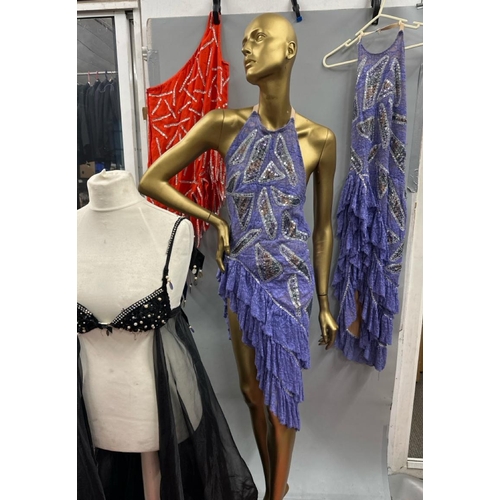 63 - Assorted stage worn garments including two purple frilly dresses, a black sequined bra top with shee... 