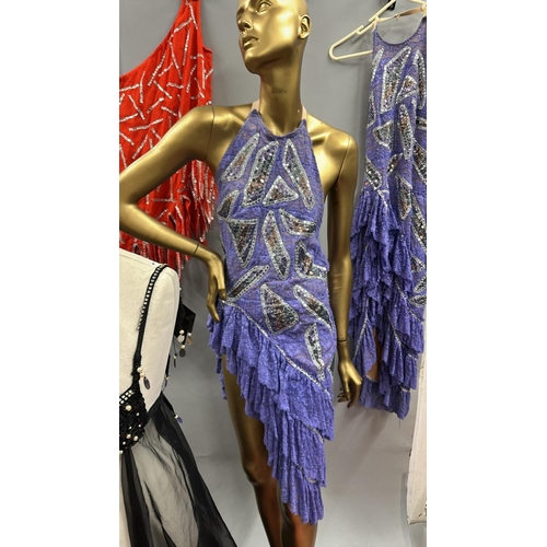 63 - Assorted stage worn garments including two purple frilly dresses, a black sequined bra top with shee... 