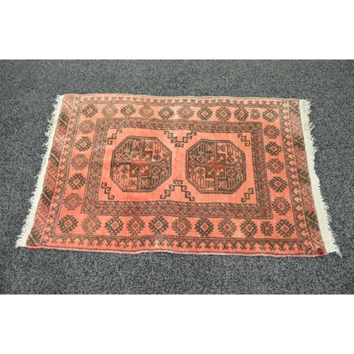 16 - Red ground rug having black pattern with end tassels - 46'' x 32''