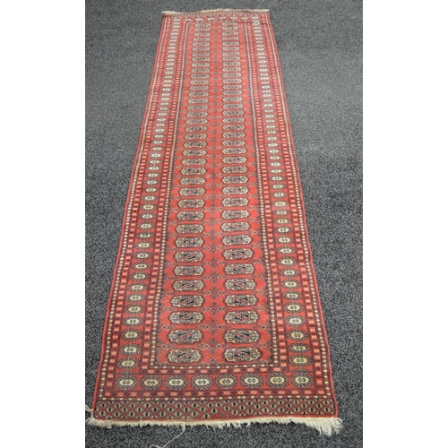 3 - Red ground carpet runner having cream and black pattern with end tassels - 124'' x 33.5''