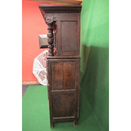 22 - Period oak buffet/court cupboard the top having heavily carved decoration with two panelled doors on... 