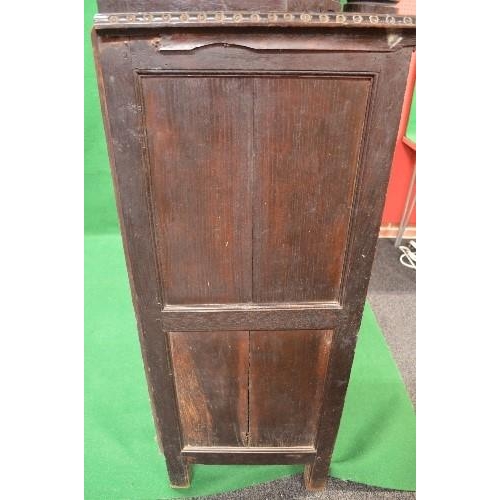 22 - Period oak buffet/court cupboard the top having heavily carved decoration with two panelled doors on... 