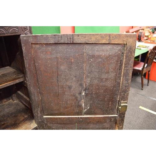 22 - Period oak buffet/court cupboard the top having heavily carved decoration with two panelled doors on... 