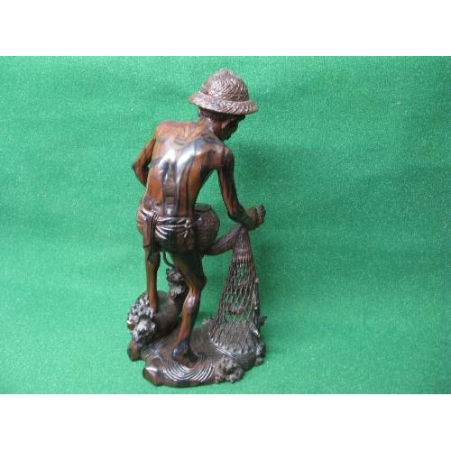 281 - Hardwood carved figure of a fisherman pulling his nets and catch from the water - 19.75