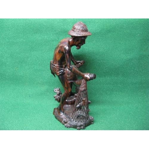 281 - Hardwood carved figure of a fisherman pulling his nets and catch from the water - 19.75