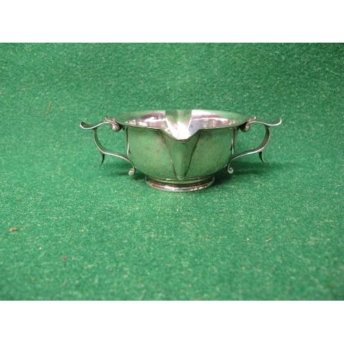 400 - An Arts & Crafts silver two handled and double spouted porringer style bowl raised on circular foot,... 