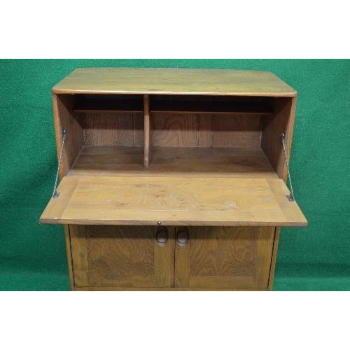 96 - Mid elm bureau having fall front opening to reveal writing surface over two cupboard doors and singl... 