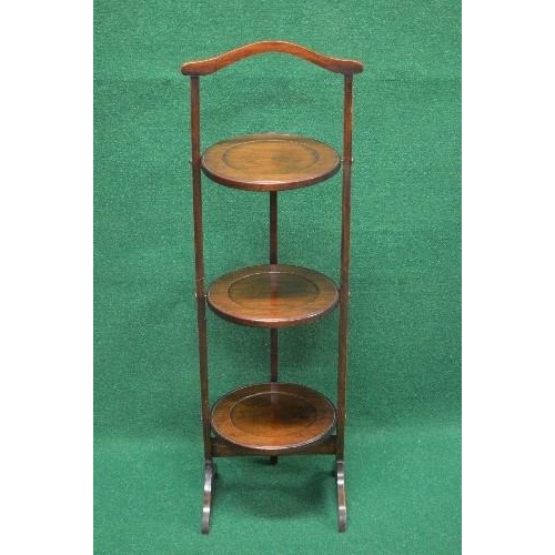 110 - Mahogany folding three tier cake stand having top carrying handle over three folding circular tiers ... 