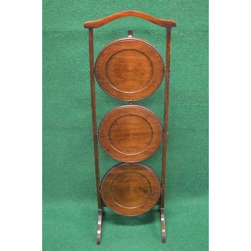 110 - Mahogany folding three tier cake stand having top carrying handle over three folding circular tiers ... 