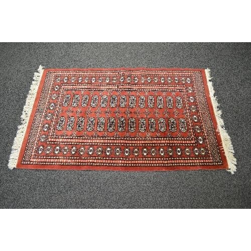 116 - Red ground rug having white cream pattern with end tassels - approx 1.65m x 0.98m