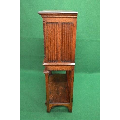 122 - Oak carved side cabinet having single panelled door carved with decoration of a figure opening to re... 