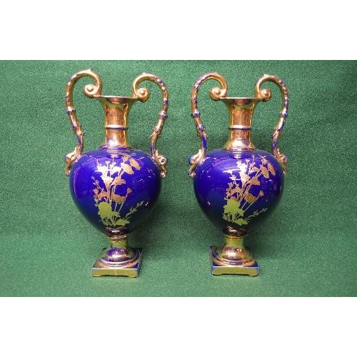 244 - Pair of blue ground two handled vases having gilt floral decoration with enamel painted birds in fli... 