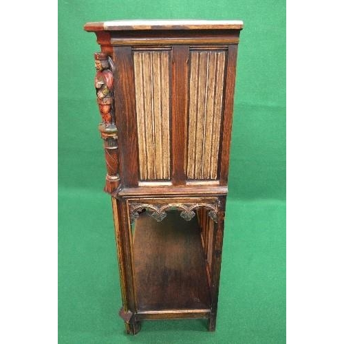 33 - Oak carved side cabinet having cut corners the top having two panelled doors decorated with carved p... 