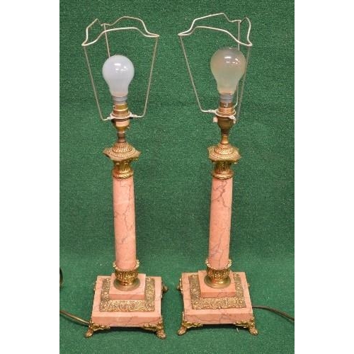 344 - Pair of pink marble table lamps having gilt metal mounts with pink marble columns leading to a stepp... 