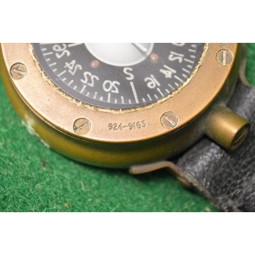 408 - Brass cased navigators compass having leather strap with brass clasp the compass case being marked 9... 