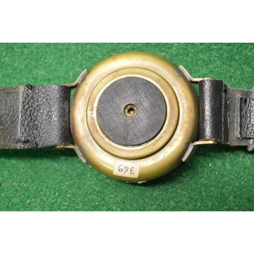 408 - Brass cased navigators compass having leather strap with brass clasp the compass case being marked 9... 