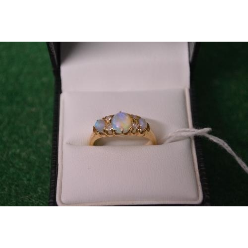 481 - 18ct yellow gold ladies ring set with central opal flanked by two small diamonds and further single ... 