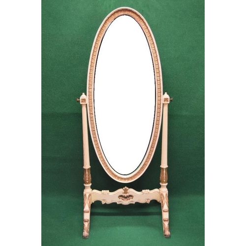 63 - Cream and gilt painted cheval mirror having oval mirror supported on outward tapering reeded columns... 