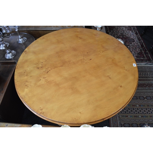 104 - Circular centre table the top having moulded edge and supported on a central carved column flanked b... 