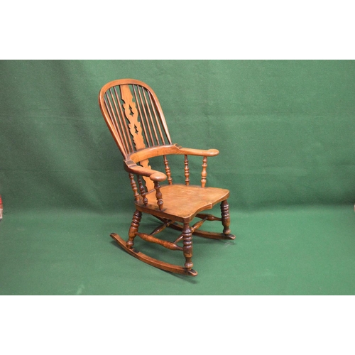 13 - Windsor style rocking chair having pierced back splat and spindles over shaped solid seat, supported... 