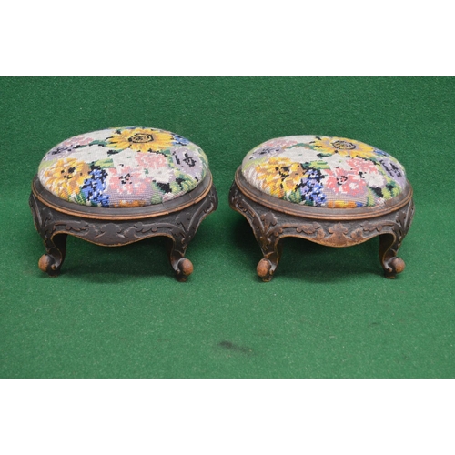 17 - Pair of Victorian circular foot stools having embroidered overstuffed tops supported on a carved fra... 