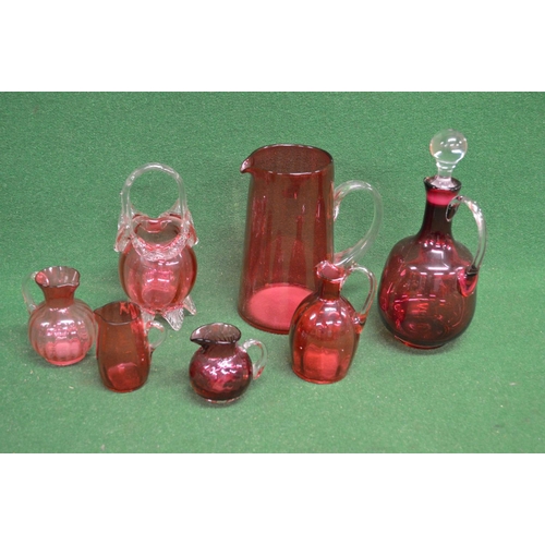 335 - Quantity of Cranberry glassware to comprise: five jugs of varying forms and sizes, one decanter with... 