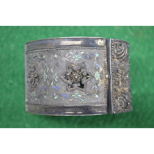 424 - Unmarked white metal and enamelled bangle (43gms) together with a cameo brooch having unmarked yello... 