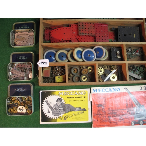 229 - Two wooden boxes of assorted Meccano parts including wheels, gears, two clockwork motors etc