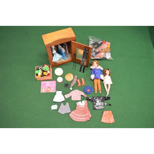 331 - Two dolls with bespoke wooden wardrobe, Sindy set booklet with selection of Sindy clothes, other clo... 