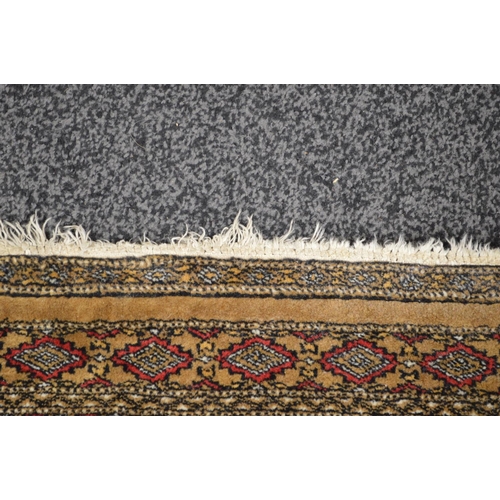 31 - Beige ground rug having red, black and cream pattern with end tassels - 1.99m x 1.29m