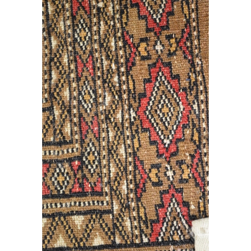 31 - Beige ground rug having red, black and cream pattern with end tassels - 1.99m x 1.29m