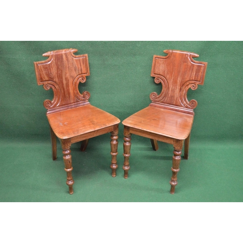 50 - Pair of 19th century hall chairs having shaped solid backs over solid seats, standing on turned legs