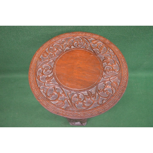 57 - 20th century hardwood carved occasional table having circular top raised by three Tibetan style carv... 